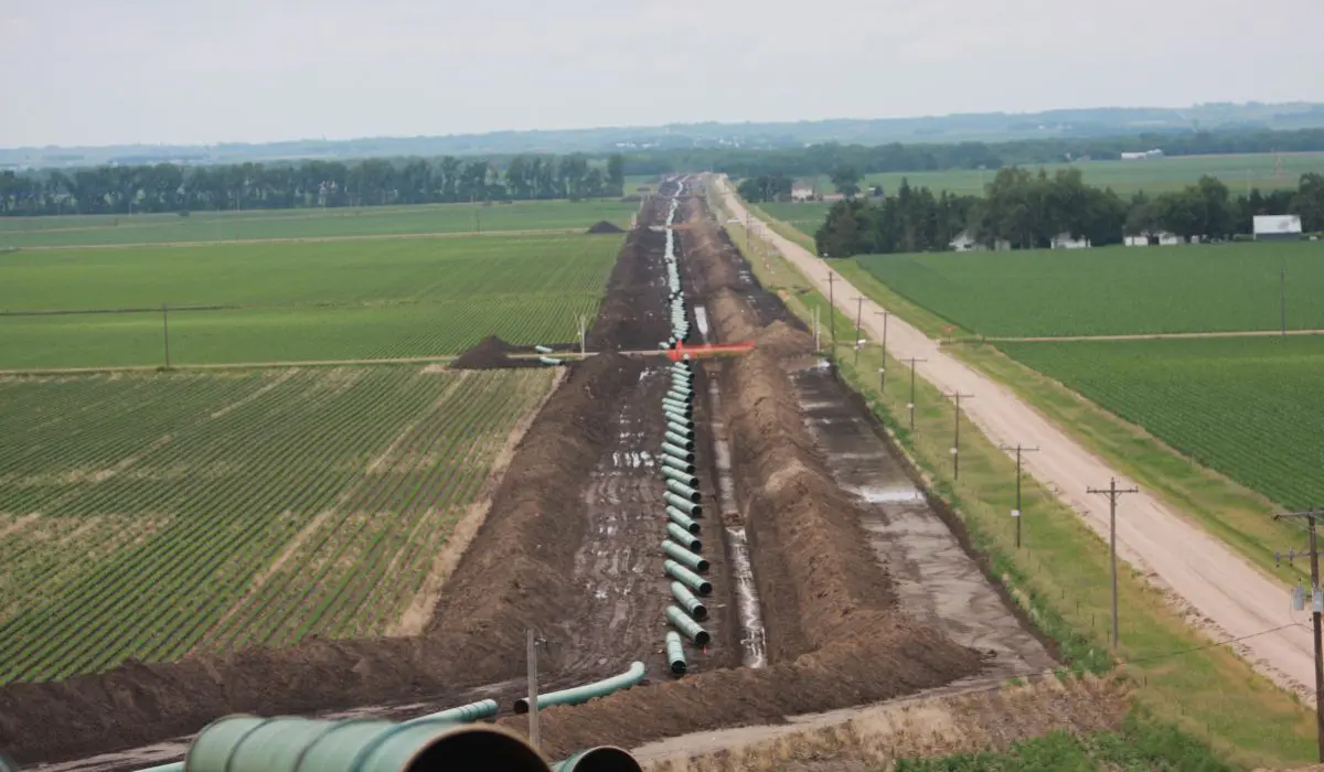 A pipeline laying in the middle of an empty field.