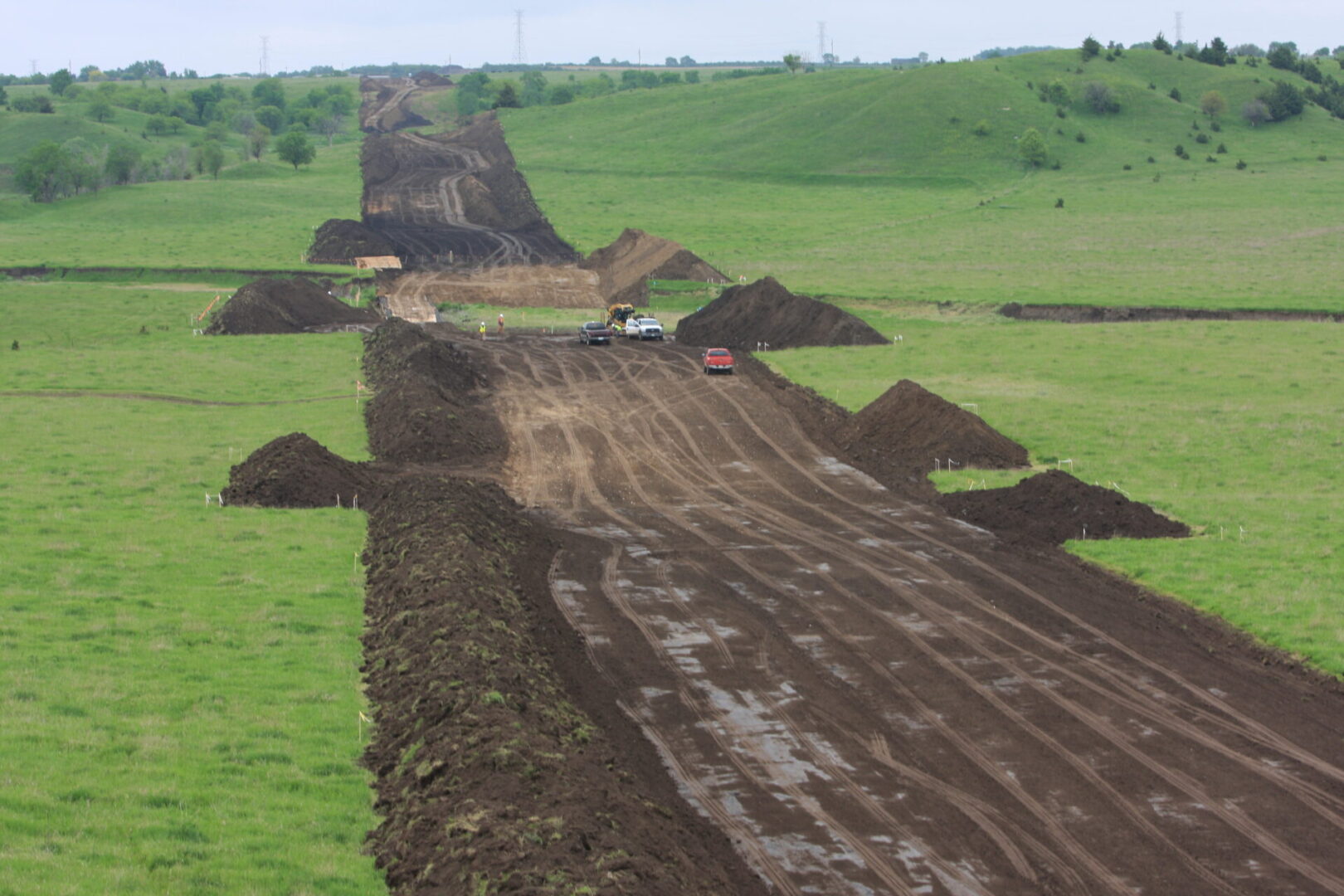 A dirt road with lots of piles of dirt on it.